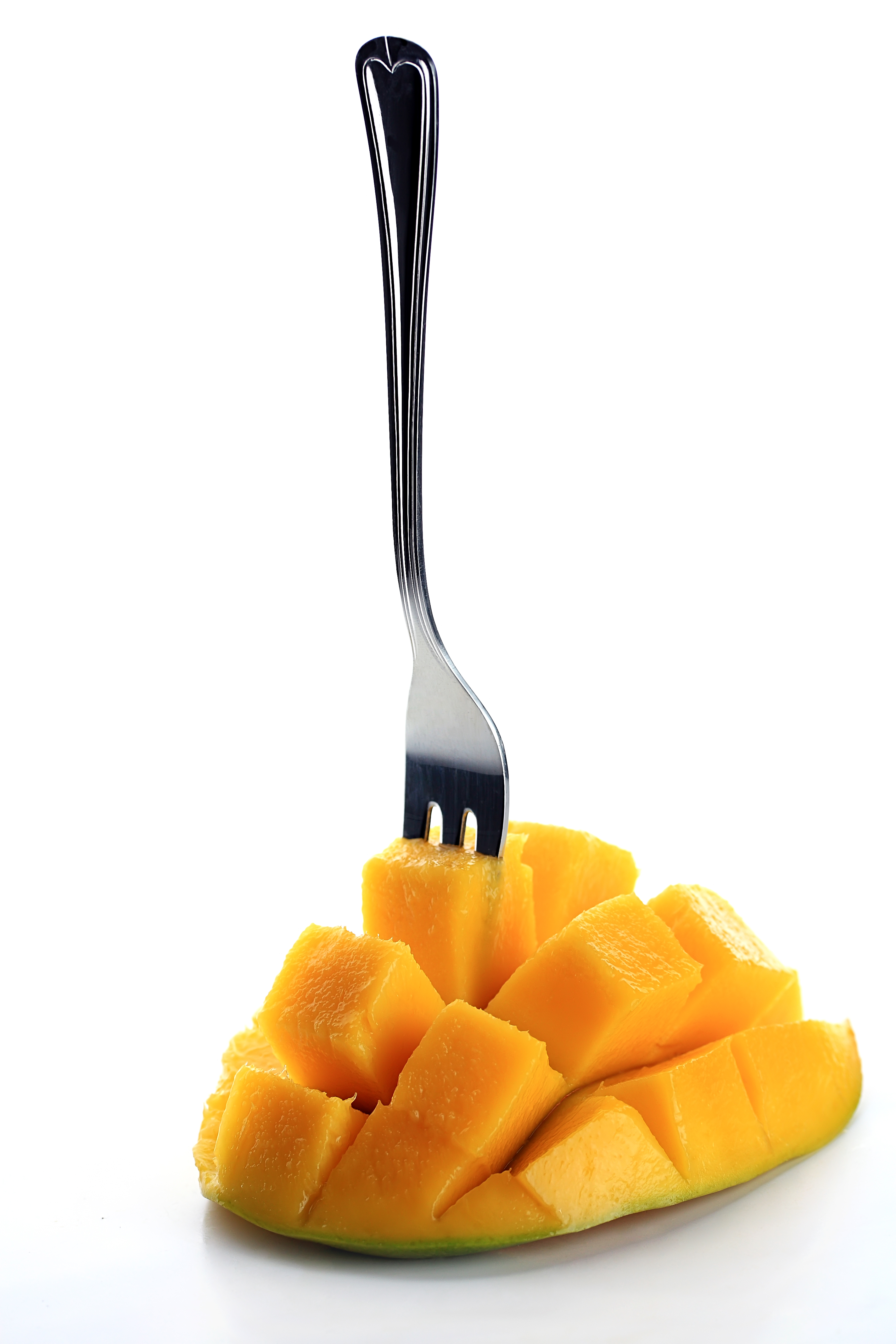 Fresh mango with fork isolated on a white background