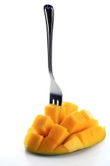 Fresh mango with fork isolated on a white background